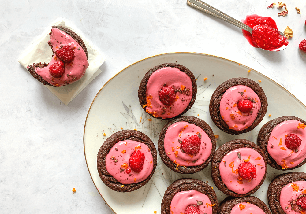 Chocolate beet cupcakes with raspberry orange frosting with a bite out of one of the cupcakes.