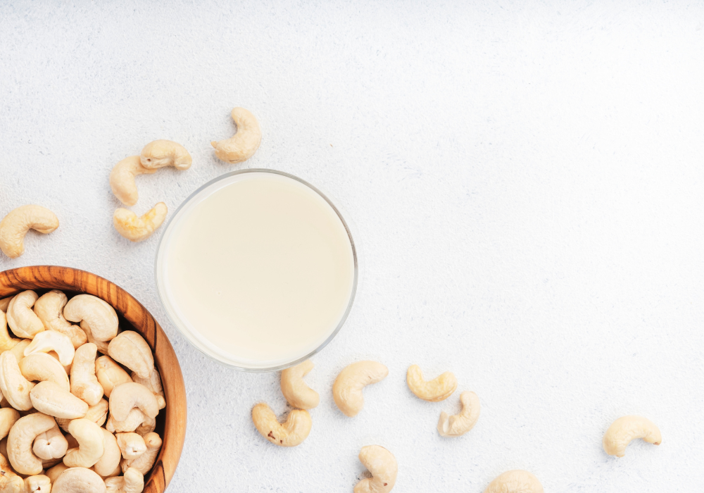 This image shows cashew cream surrounded by whole cashews, which is an easy plant-based alternative that you can whip up at home.