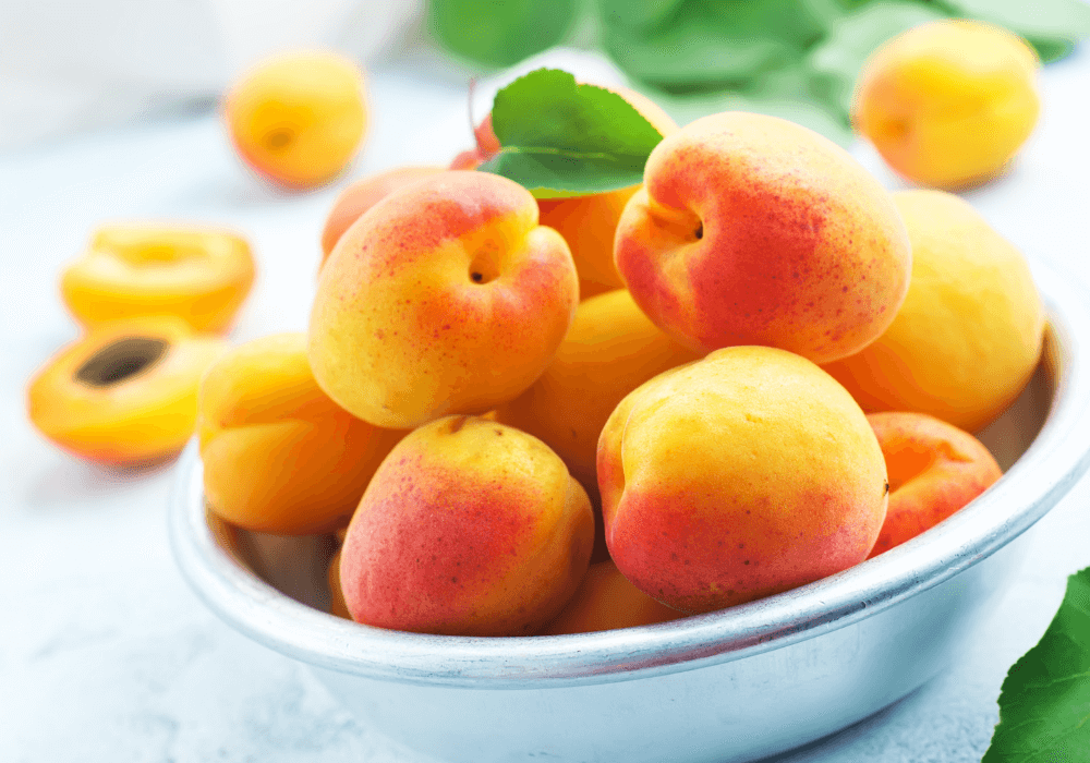 Fruit is full of sugar, but it's actually one of the healthiest foods! This photo shows apricots in a bowl as one of those healthy fruits.