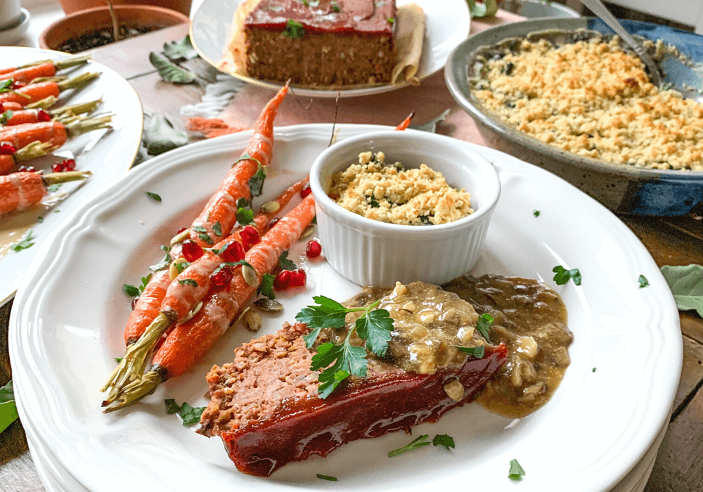 This image shows a delicious plant-based meal of no-meatloaf with mushroom gravy, roasted carrots, and a creamy kale gratin. This meal is an example of the types of meals one can make with meal planning.