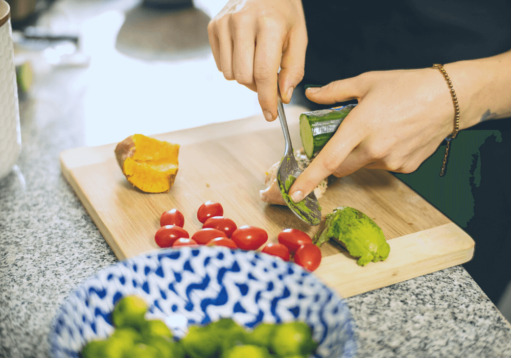 This photo shows a woman preparing and cutting vegetables before starting to cook a meal.