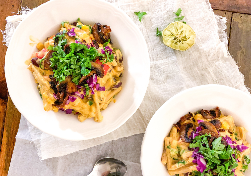 This image shows the healthy loaded mac and cheese in bowls on a table.