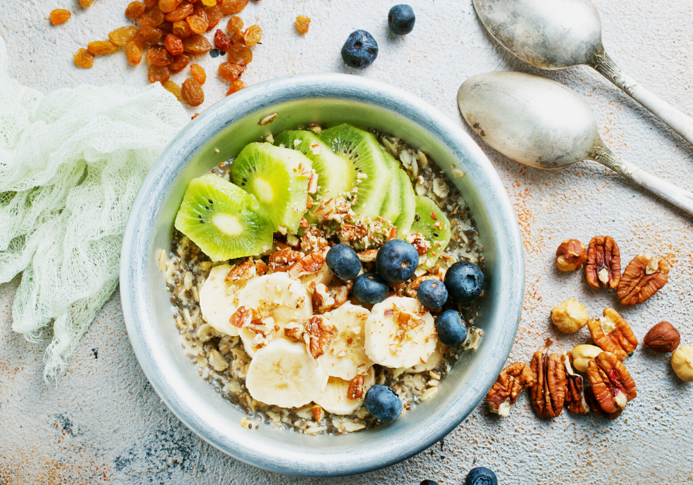 This image shows my typical breakfast: a bowl of oatmeal with berries, cut fruit, nuts, seeds, and soymilk. 