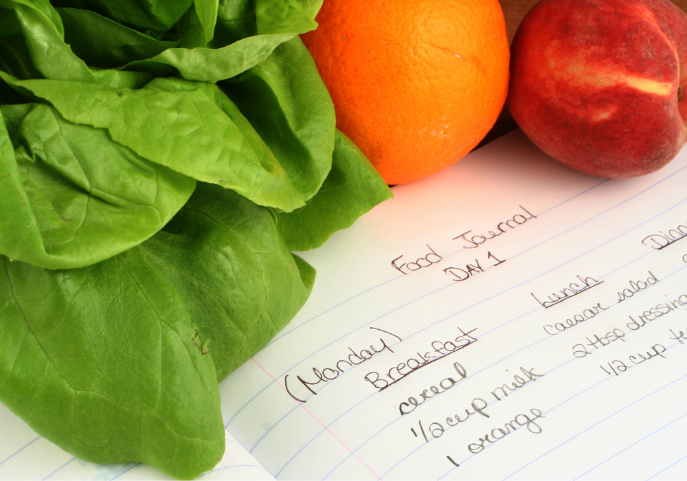 This image shows an example food journal plus colorful fruits and veggies.