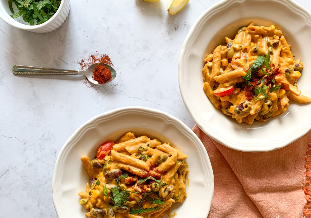 This image shows two bowls of delicious healthy loaded mac and cheese, a super comforting meal in times of stress.