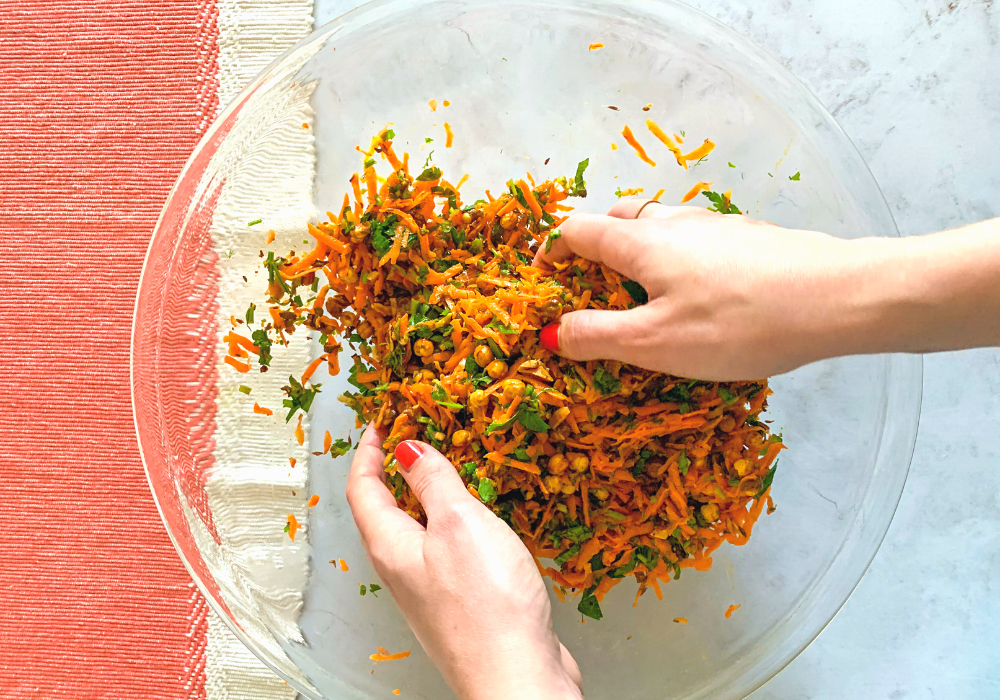 This image shows the carrot salad being mixed in a bowl. 