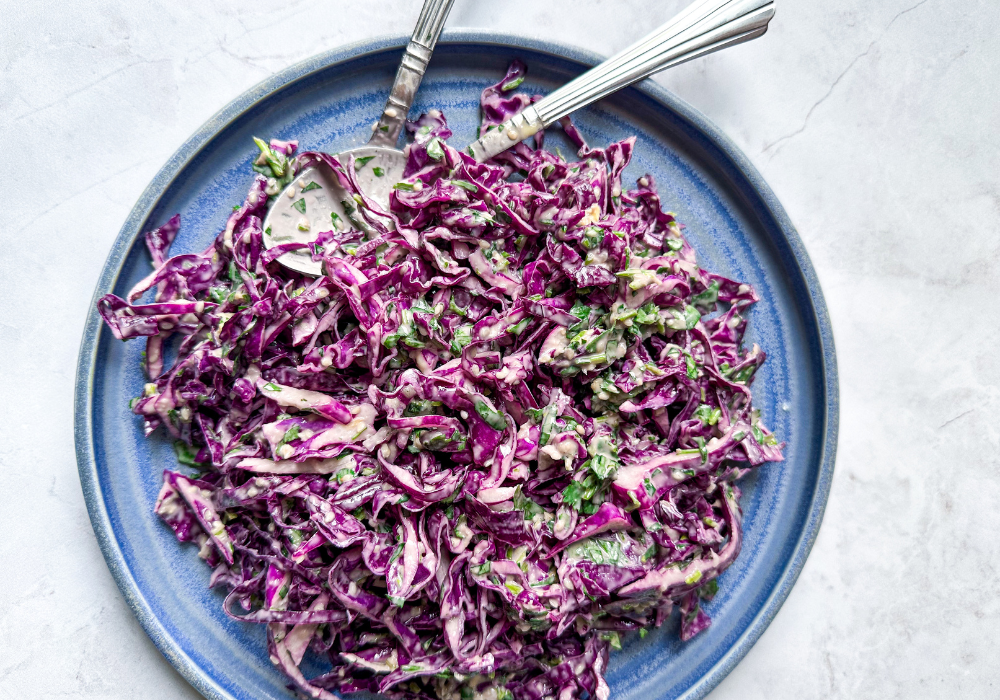 This image shows a close up of the crunchy red cabbage slaw on a blue plate.