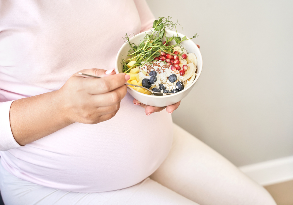 This image shows a pregnant woman holding a bowl of healthy food.